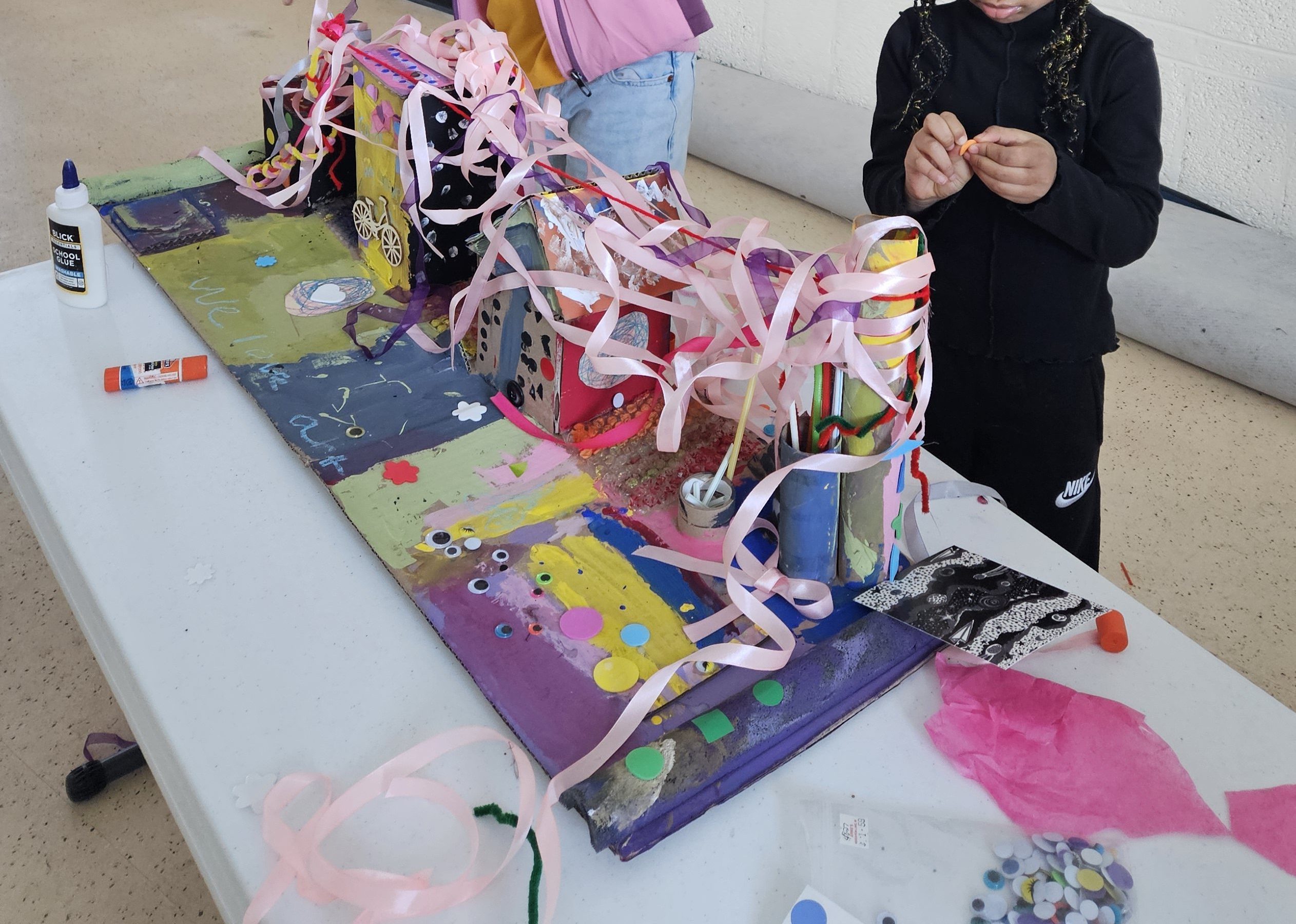Children working on colorful 3D assemblage of houses 